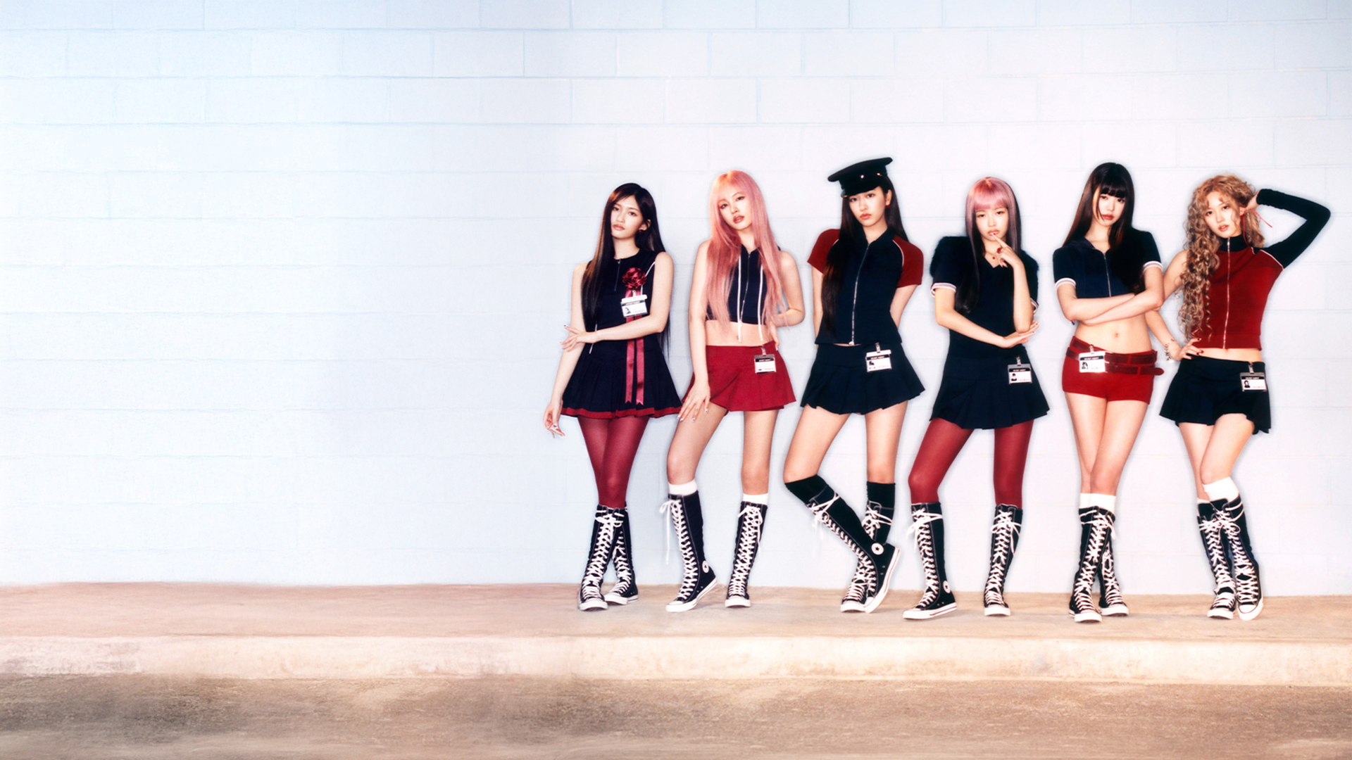 IVE band members posing in black, white and red clothing against a wall.