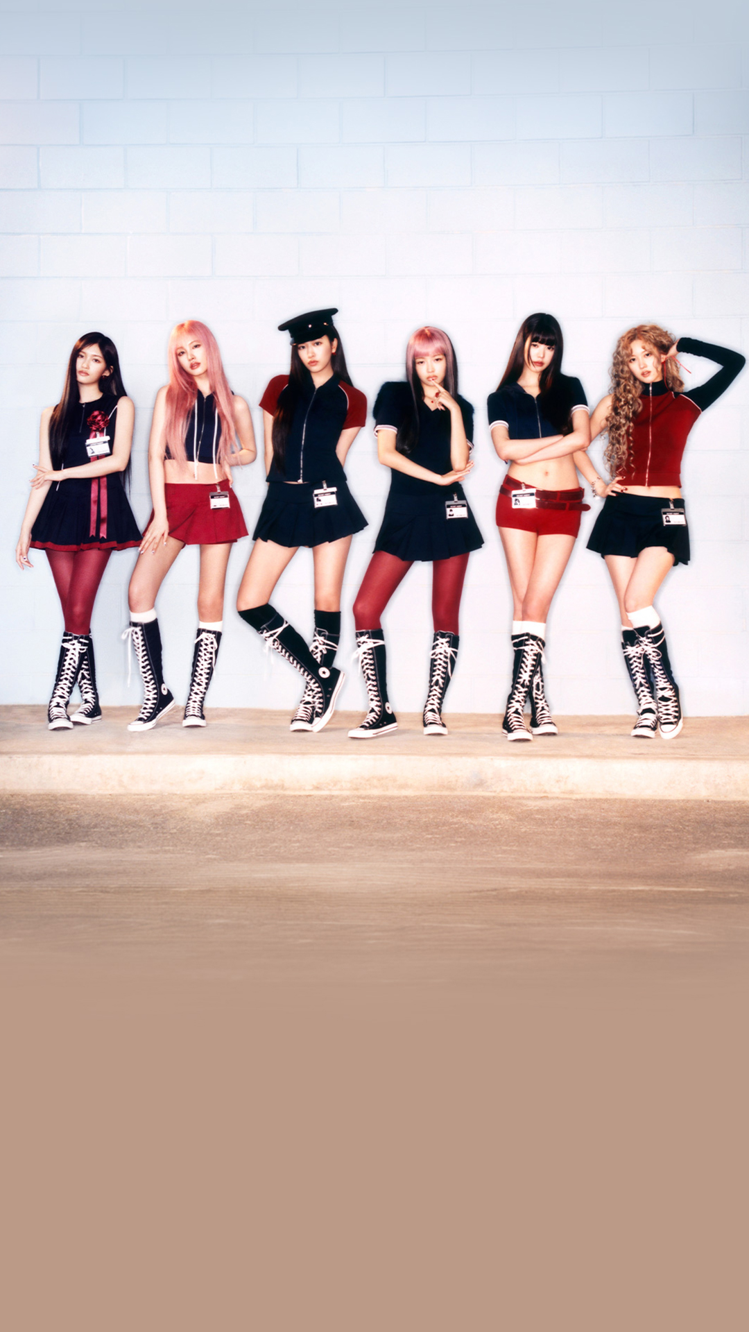 IVE band members posing in black, white and red clothing against a wall.