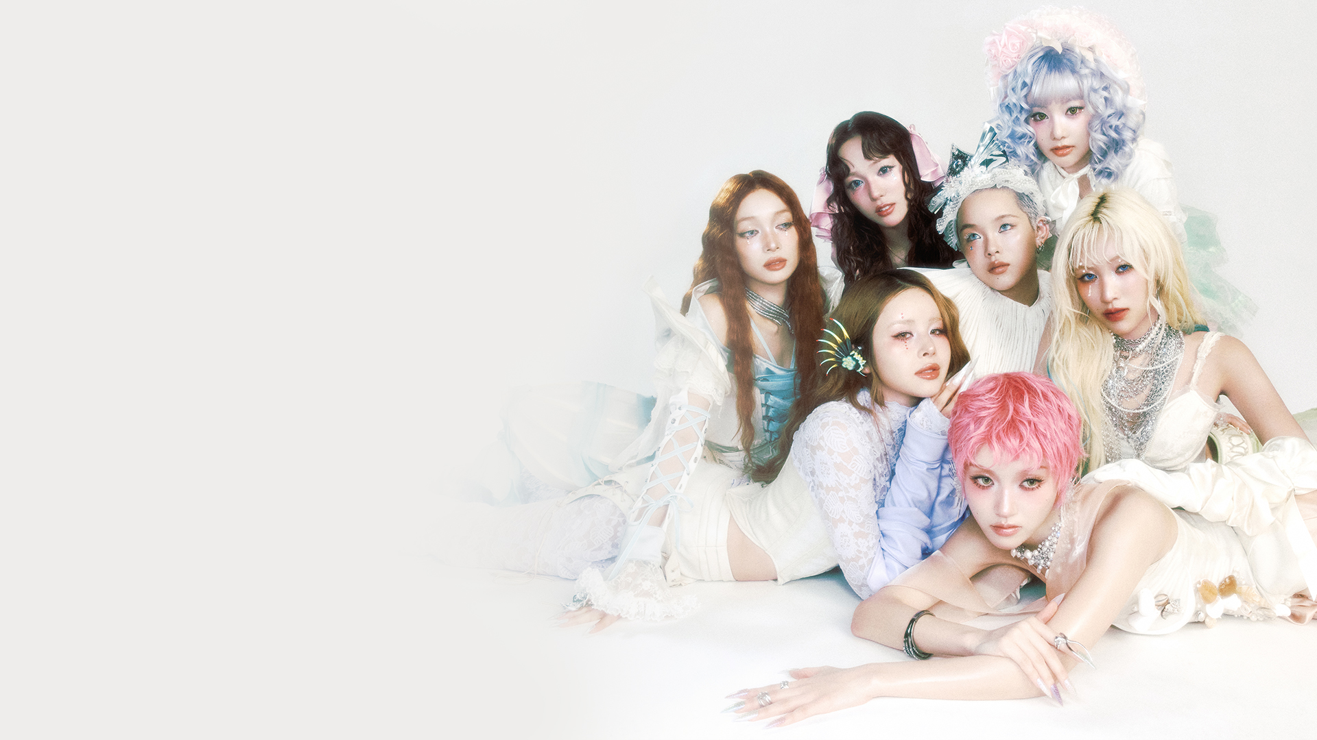 XG band members dressed in matching white and pink outfits, posing together.