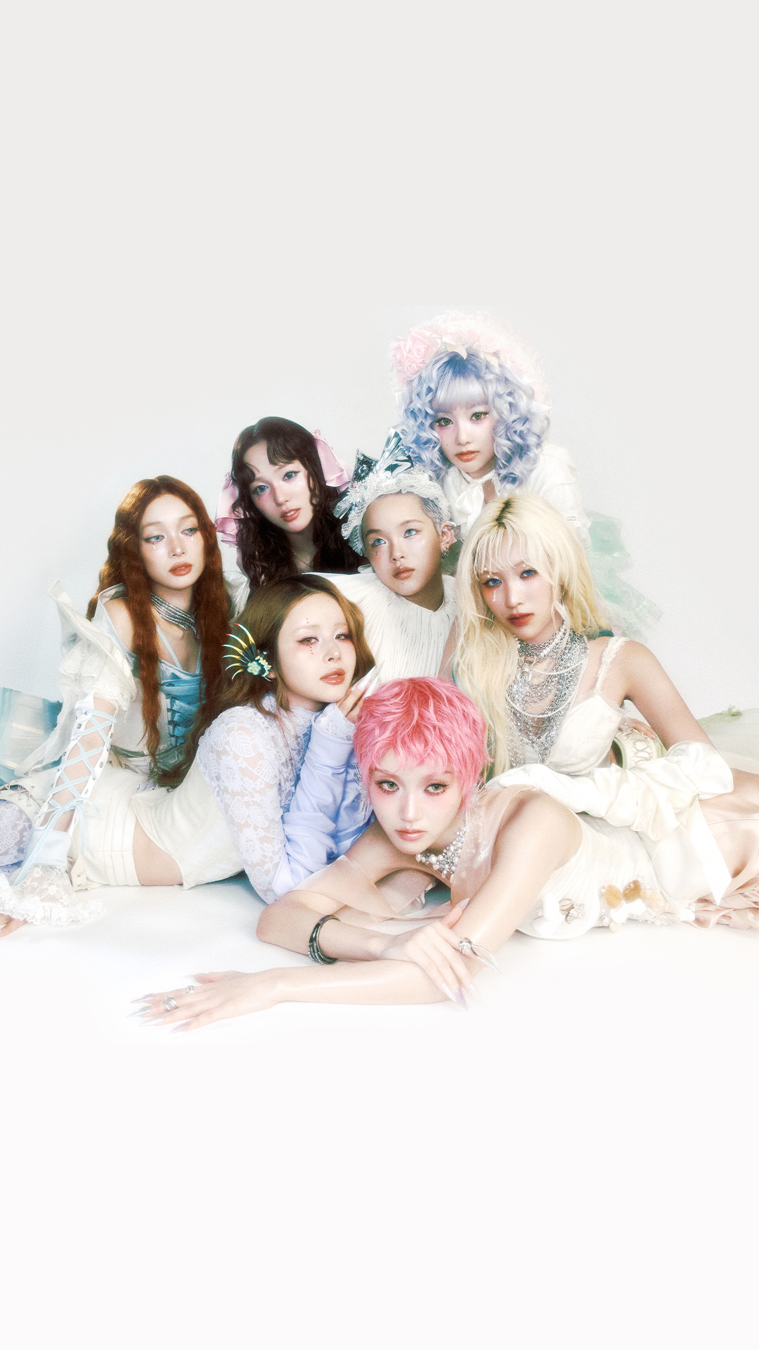 XG band members dressed in matching white and pink outfits, posing together.
