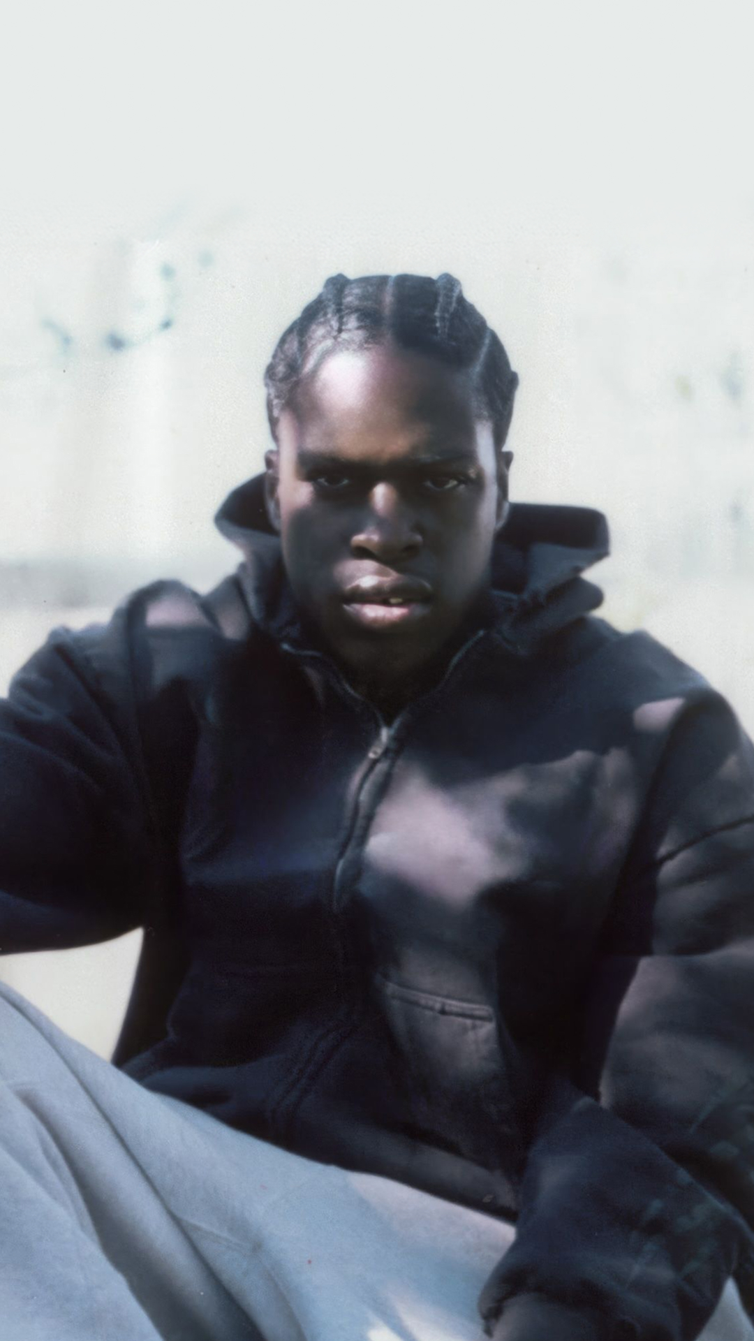 Daniel Caesar with dreadlocks gazes directly at the camera.