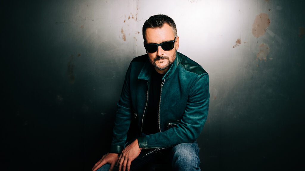 Eric Church with sunglasses on poses for the camera.