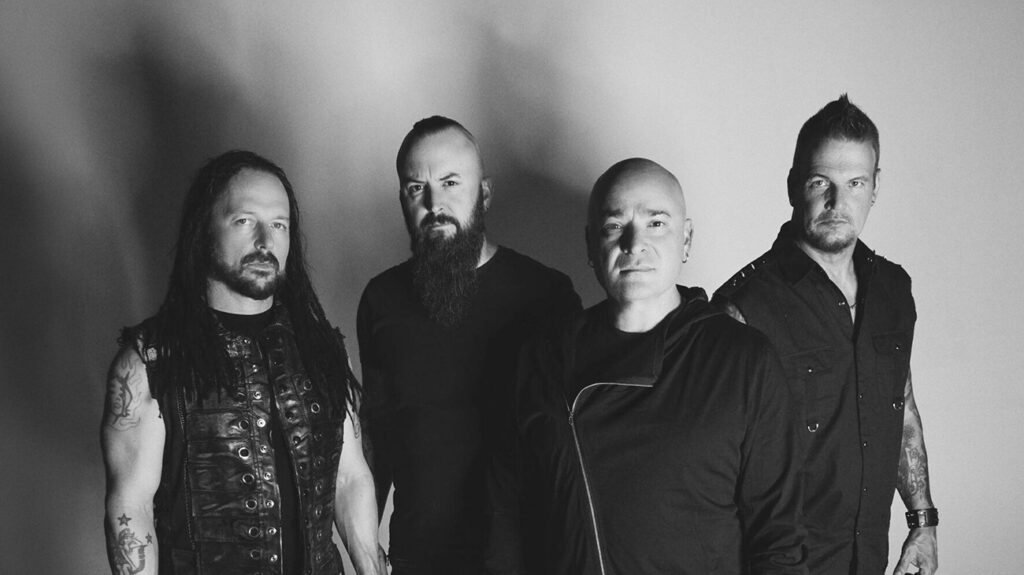 Disturbed band members pose together in a black and white photo.